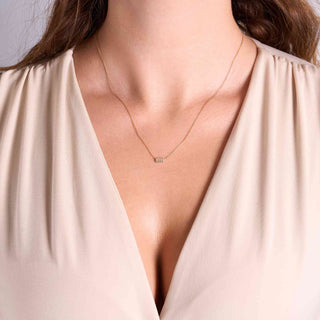 Model wearing a dainty baguette diamond necklace.