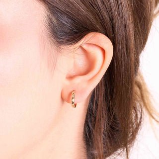Bezel-set diamond huggie hoop earrings in 14k gold worn on ear