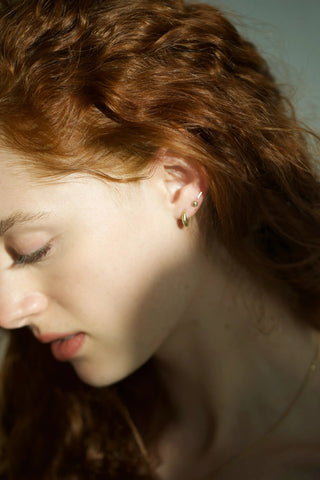 Miniature foiled half sphere stud earrings in 14k gold, worn on ear