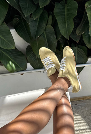 The Bond Society delicate gold anklet styled with casual yellow sneakers, minimalist fine jewelry for everyday wear