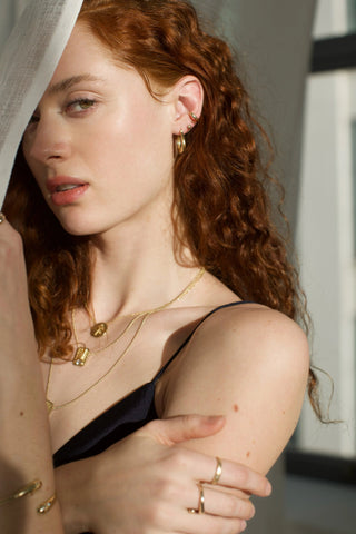 Radiant sunrise pendant set with white topaz on a 14k gold ball chain, worn layered