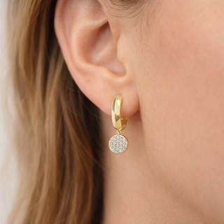 Delicate pavé diamond drops on a 14k gold hoop, worn on ear
