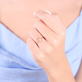 Dainty pavé diamond heart ring in 14k gold worn on finger