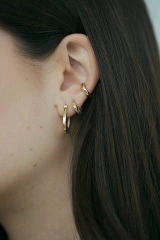 Sculptural foiled ear cuff in 14k gold worn on upper ear